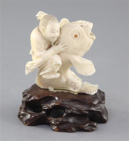 A Japanese ivory group of Kinko riding a carp, Meiji period, height 7.5cm, wood stand